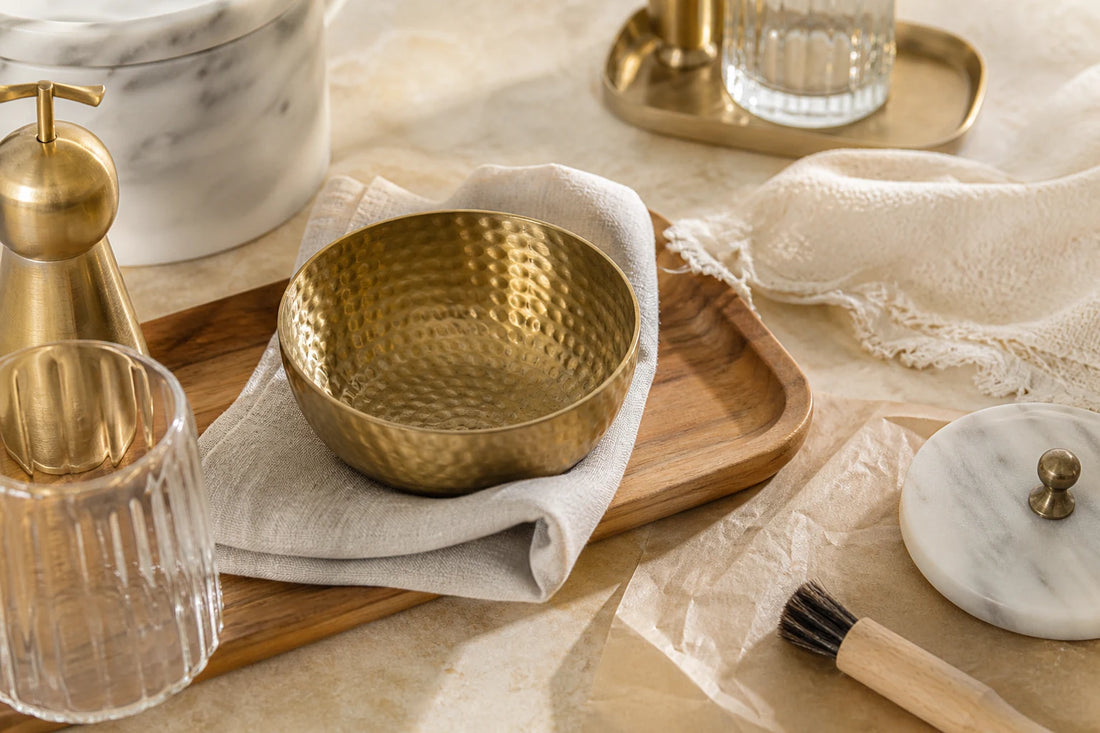 TATPUB marble, brass, glass, and teak hosting pieces arranged with a soft cloth for care guidance.