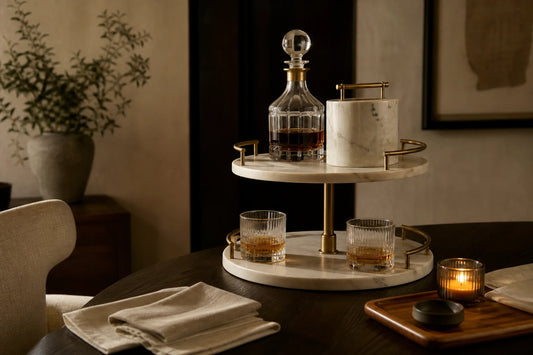 A calm home hosting setup with TATPUB hosting system, teak tray, glassware, and candlelight.