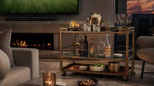 A luxury match night living room with the TATPUB marble and hammered brass hosting system, brass ice bucket, and marble coasters.